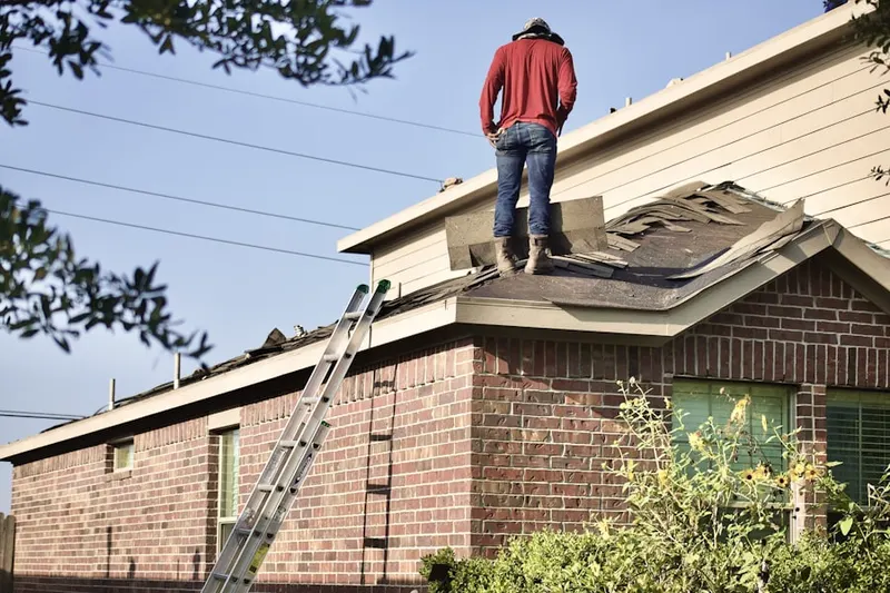 Professional roofer working on a residential roof in Country Club Ridge